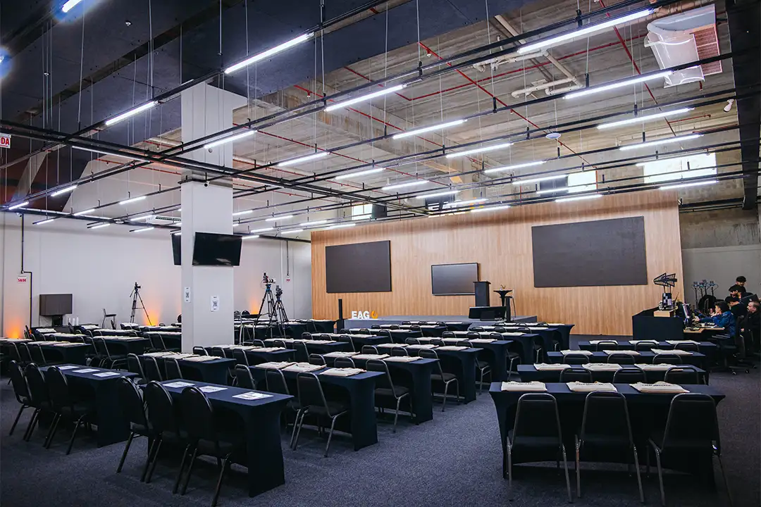 Plenária do Centro de Eventos EAG em formato escolar com mesas e cadeiras para treinamentos corporativos
